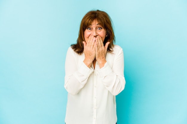 Senior caucasian woman isolated laughing about something, covering mouth with hands.