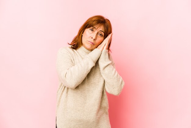 Senior caucasian woman isolated yawning showing a tired gesture covering mouth with hand.