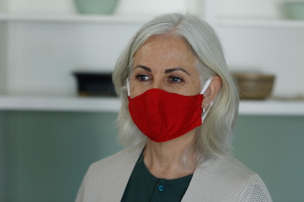 Senior caucasian woman wearing face mask at home. social distancing quarantine lockdown during coronavirus pandemic