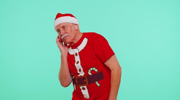 Senior christmas old grandfather man listening music via earphones dancing fun disco fooling around