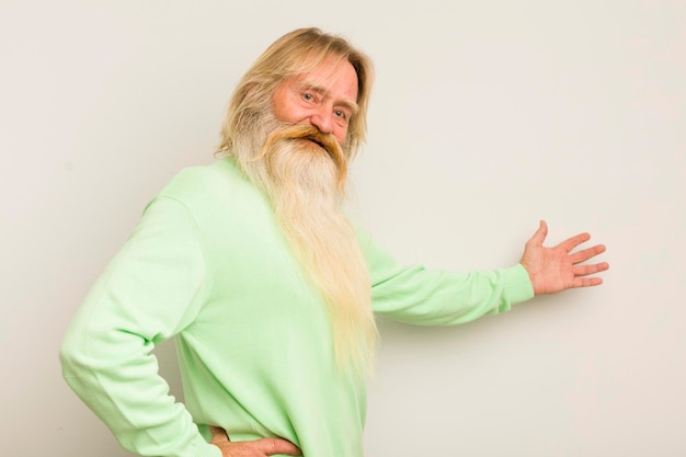 Photo senior cool bearded man feeling happy and cheerful smiling and welcoming you inviting you in with a friendly gesture