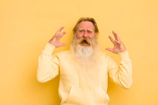 Foto uomo barbuto freddo anziano che urla con le mani in aria sentendosi frustrato, stressato e sconvolto