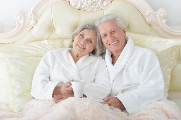 Senior couple in bed with tea at home