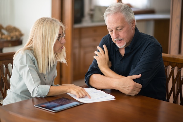 Coppie senior che calcolano insieme le loro spese di soggiorno