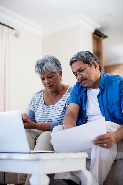 Senior couple checking bills in living room