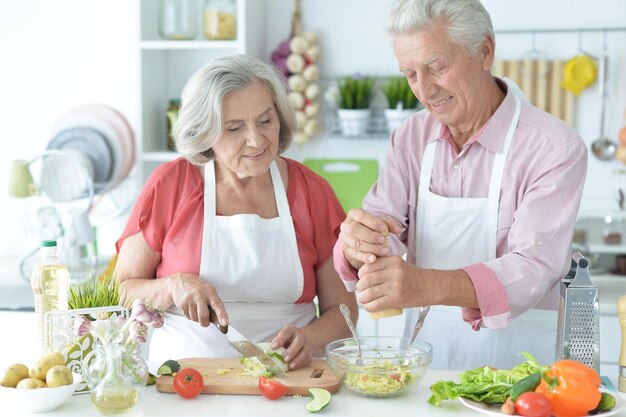 Senior couple cooking together at kitchen