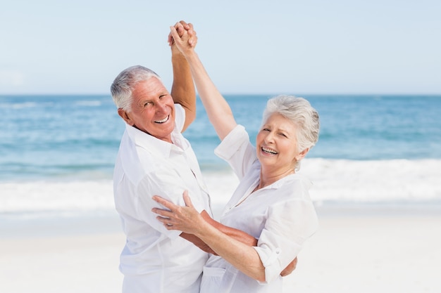 Coppia senior ballare in spiaggia