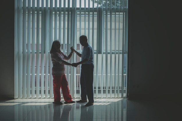 Senior couple dancing near the window