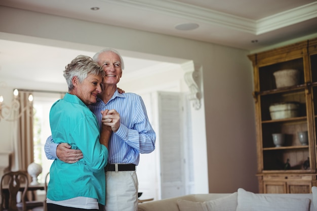 Senior couple dancing together in living room