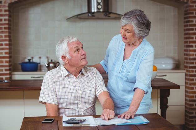 Senior couple discussing with bills 