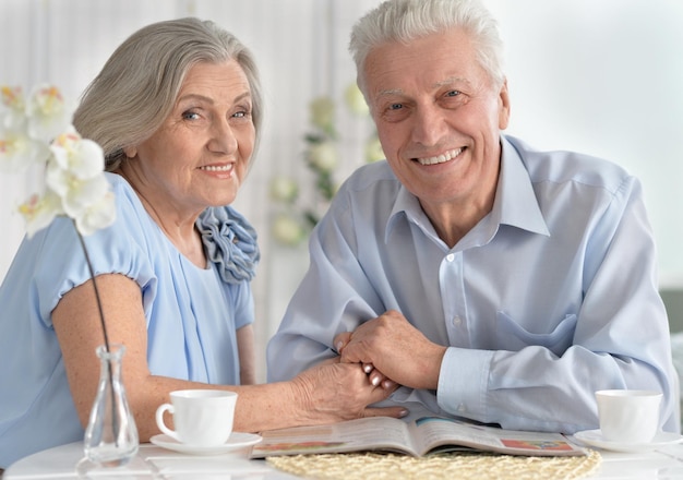 Photo senior couple drinking tea and reading magazine