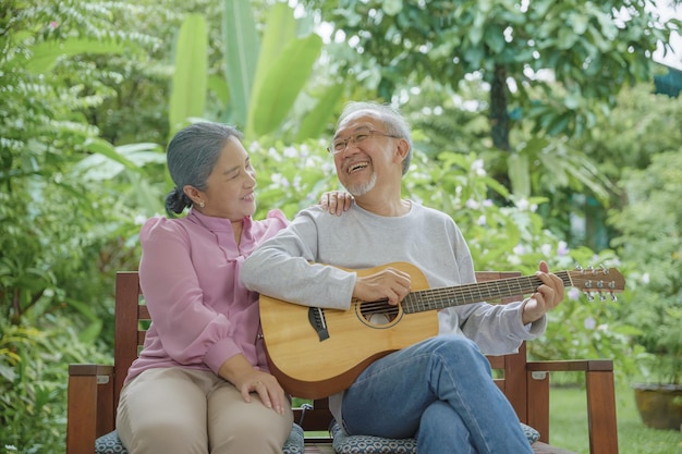 Senior couple elderly man playing the guitar while his wife is singing together