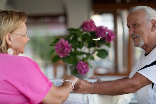 Senior couple of elderly man and woman in love holding hands and looking to each other Romantic dating concept Selective focus on hands