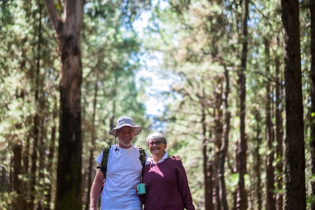 Senior couple enjoy together outdoor leisure activity walking in the forest