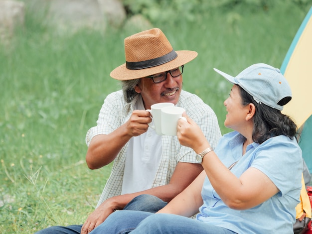 Senior Couple Enjoying Camping trip, They drink coffee in the morning together.