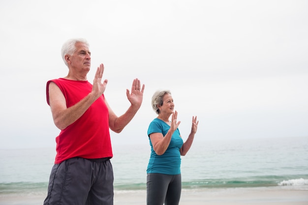 Photo senior couple exercising on the beach