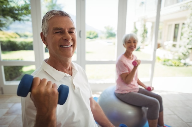 Photo senior couple exercising with dumbbells on exercise ball