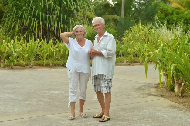 Пожилая пара развлекается возле курортного отеля