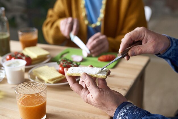 テーブルで朝食をとるシニア夫婦