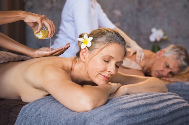 Senior couple having oil spa massage