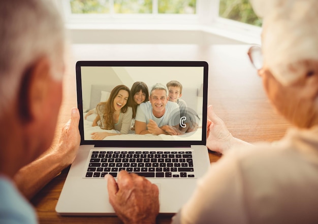 Senior couple having a video call with their family on laptop