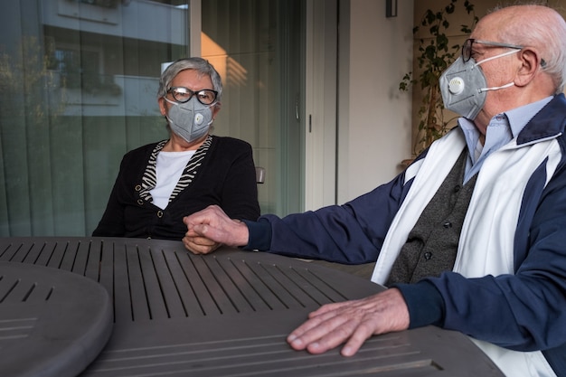 senior couple at home with masks