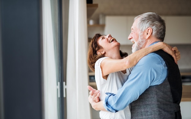 家の中で笑って抱きしめ合っている上級夫婦
