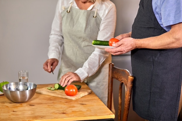 수석 부부는 부엌에서 요리입니다. 자른 여자와 잘 생긴 남자는 home.healthy 라이프 스타일 개념에서 함께 시간을 보내고있다