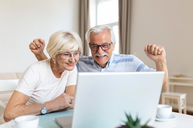 Senior couple is talking online via video connection on the laptop Having nice time withfriends and family via video call