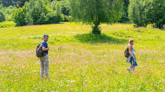 Senior couple looked back on the hiking at bright green alley. Beautiful family travel