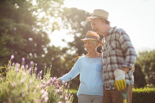 Senior couple looking at flowers in backyard