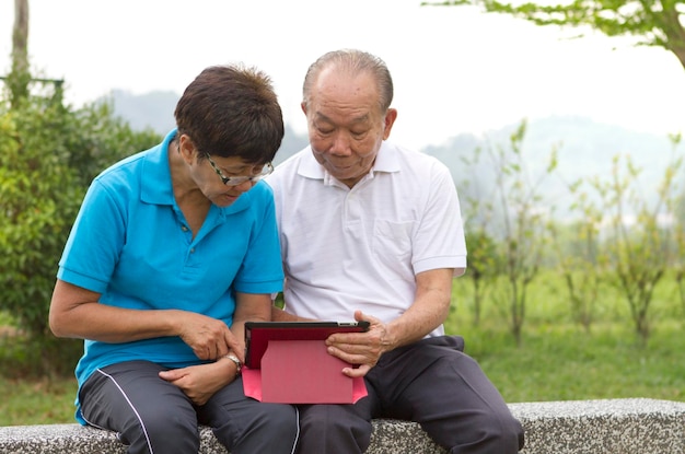 Senior couple looking at the mobile tablet