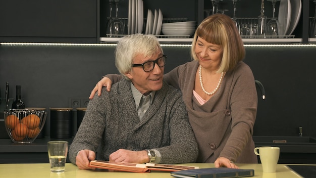 Photo senior couple looking old photo album and smiling