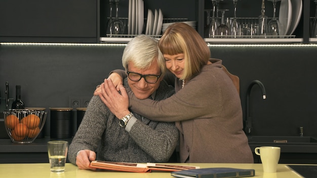 Senior couple looking old photo album and smiling