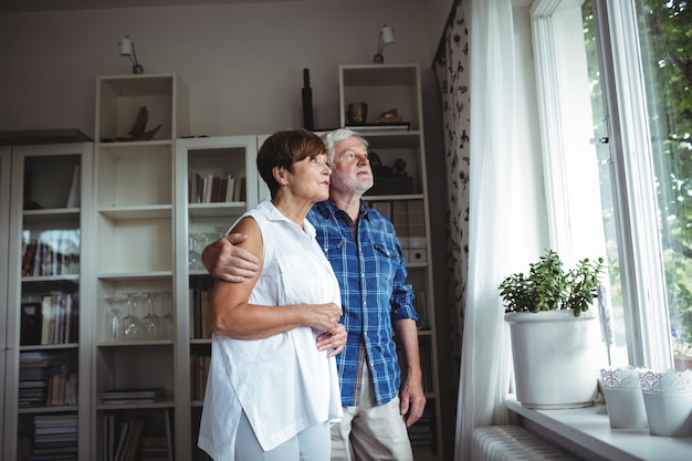 Senior couple looking through window