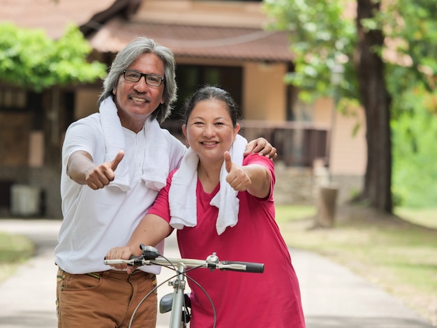 パークの自宅でサイクリングしているシニアカップルの恋人