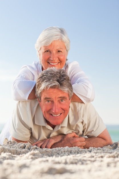 Senior couple lying down on the beach