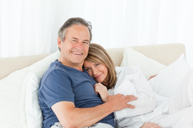 Senior couple lying down on their bed