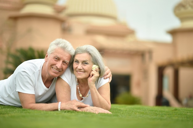 Coppia senior sdraiata al giardino dell'hotel tropicale