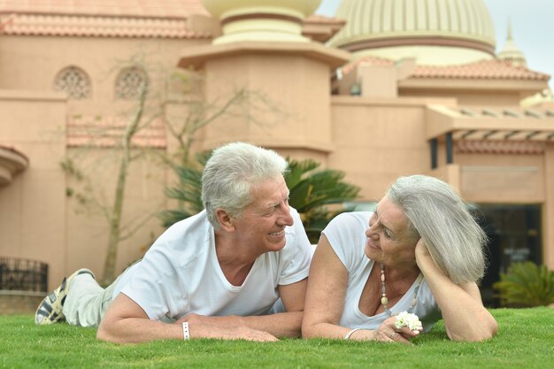 Senior couple lying at tropic hotel garden