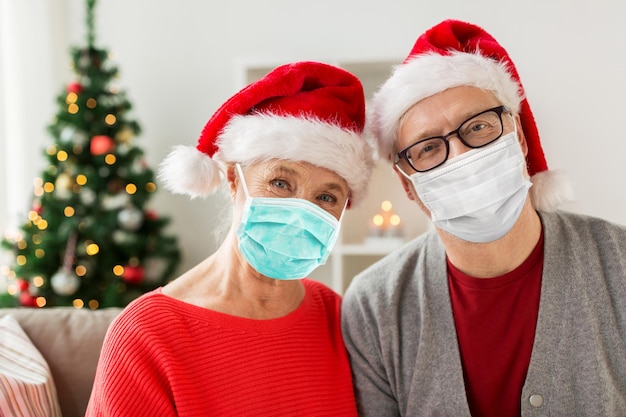 クリスマスにマスクとサンタの帽子をかぶった上級カップル