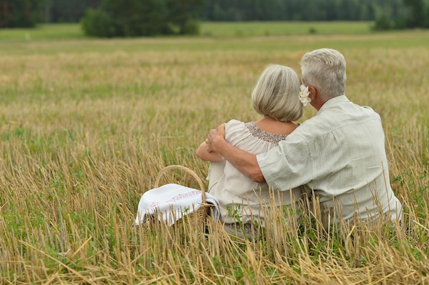 Senior couple on mowed field of wheat