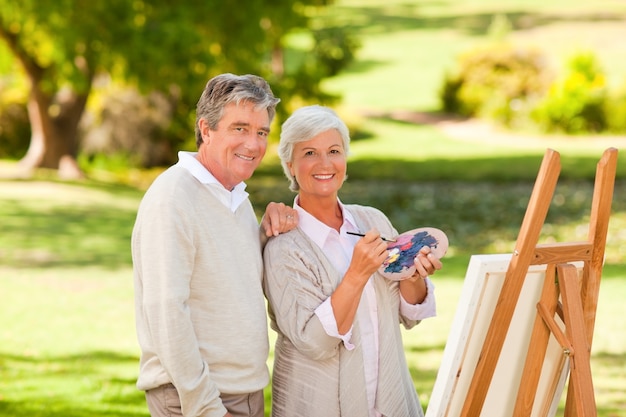 Senior couple painting in the park