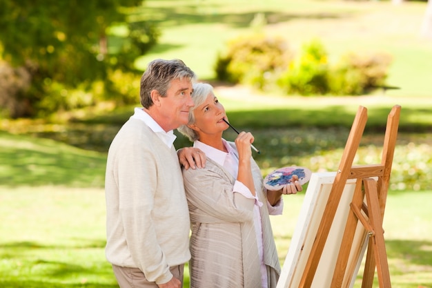 Senior couple painting in the park