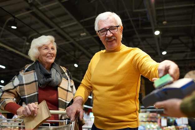 スーパーマーケットで支払い年配のカップル
