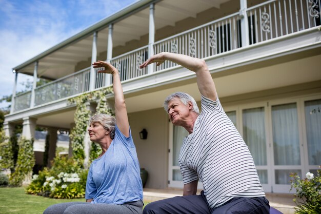 Senior couple performing stretching exercise