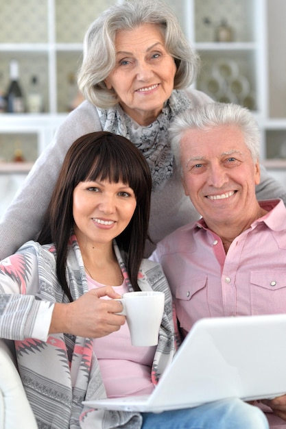 Photo senior couple portrait with laptop with caring daughter