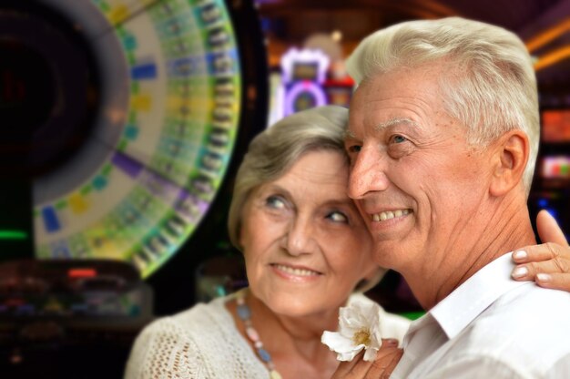 Photo senior couple posing on blurred casino background