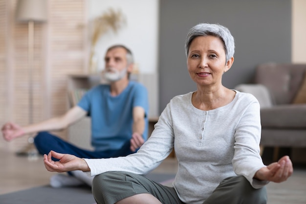 Senior couple practicing yoga at home