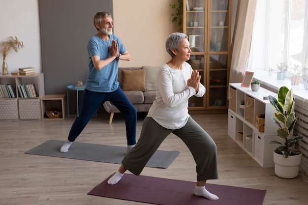 Senior couple practicing yoga at home